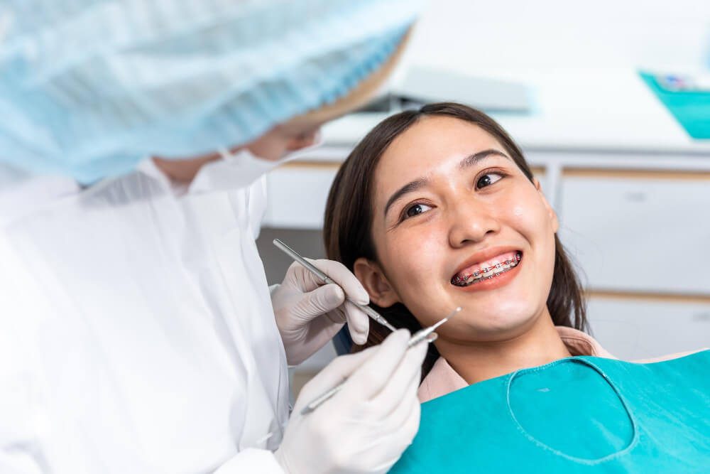 Dentist examining a patient with braces during an orthodontic consultation in Cheltenham